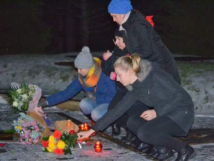 Dziewczyny składają kwiaty na grobach w Katyniu