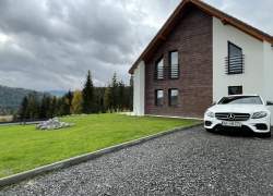 Widok zewnętrzny domu oraz biały mercedes