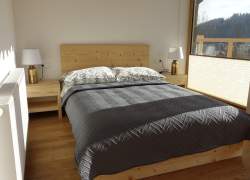 Sypialnia - łóżko małżeńskie z szarą kapą, dwie szafki nocne, a na nich lampki, duże okno, biały grzejnik