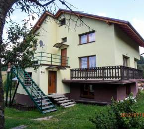Widok zewnętrzny domu; jasny tynk, schody, balkon
