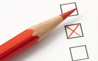 Zdjęcie przedstawia kartę wyborczą z zaznaczonym czerwoną kredką krzyżykiem.