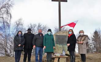 Uczestnicy obchodów stoją przy pomniku