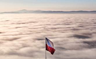 Biało-czerwona flaga na Ochodzitej, w tle morze mgły