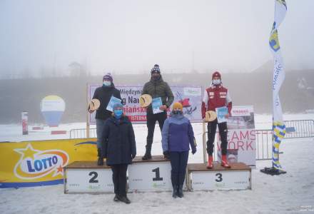 Podium w kategorii  M20: miejsce 1. Garbień Tomasz, miejsce 2. Skowron Piotr, miejsce 3. Wojtyła Wojciech; obecne: Beata Białowąs -Wicemarszałek Województwa Śląskiego, Wójt Gminy Istebna Łucja Michałek; w tle baner imprezy, banery sponsorów