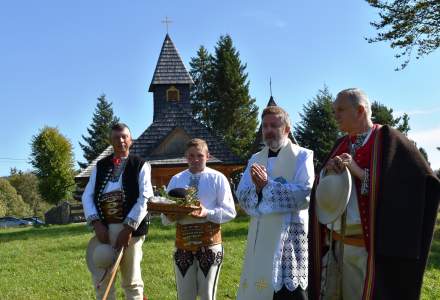 Modlitwa Księdza Proboszcza Grzegorza Kotarby wraz z bacą Janem Bzdyk, Józefem Michałkiem ubranym w strój regionalny pasterzem; w tle kościół