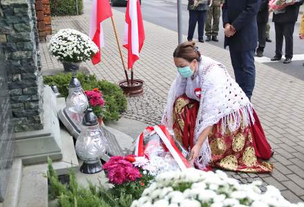 Wójt gminy Istebna Łucja Michałek składa wiązankę kwiatów pod pomnikiem pomordowanych w czasie II Wojny Światowej