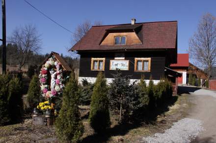 Drewniany budynek z obrazem na ścianie i kapliczka