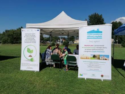 Namiot punktu konsultacyjnego Czyste Powietrze; na krzesłach siedzą zainteresowani programem mieszkańcy