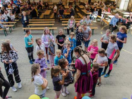 śpiewająca dziewczynka z prowadząca zabawę Colin, wokół dzieci