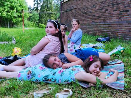 Pięć dziewczynek odpoczywa na trawie