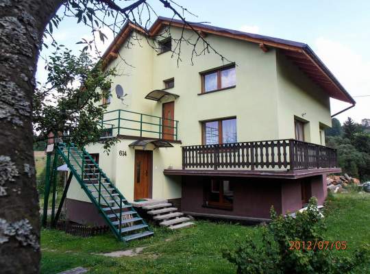 Widok zewnętrzny domu; jasny tynk, schody, balkon